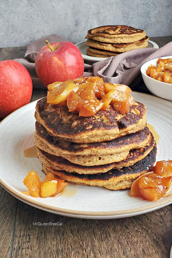 gluten free apple pie spice pancakes topped with cooked apples