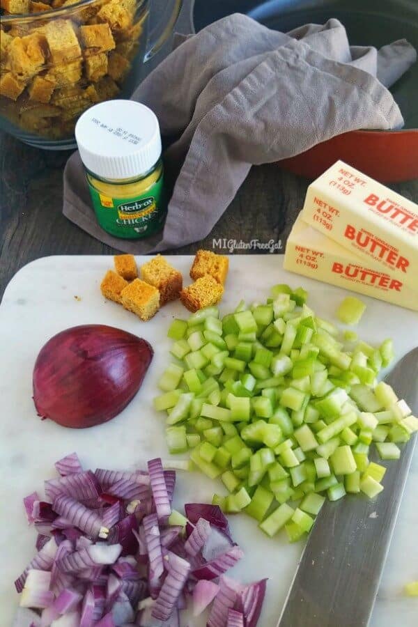 Gluten Free Cornbread Stuffing with chopped onions and celery on cutting board