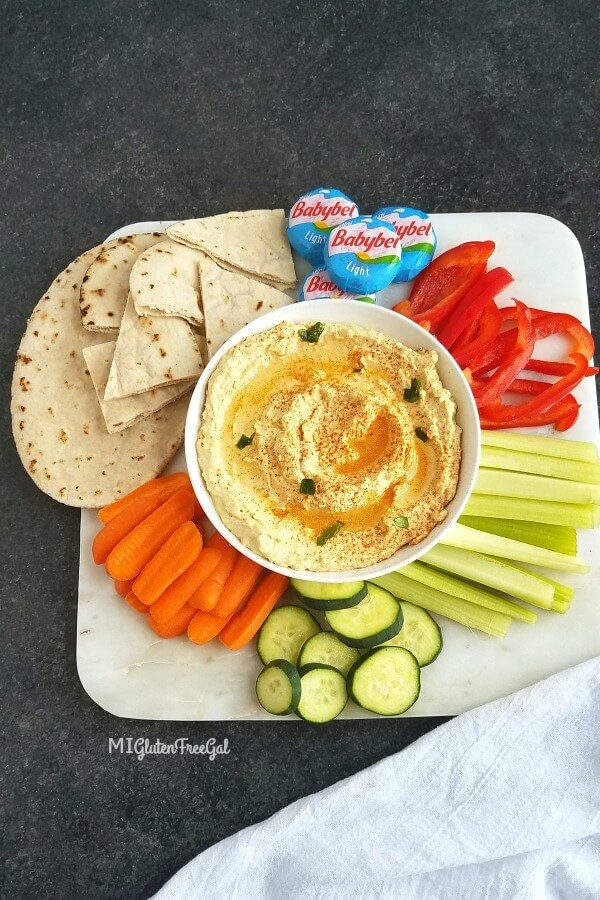 hummus in bowl surrounded by vegetables