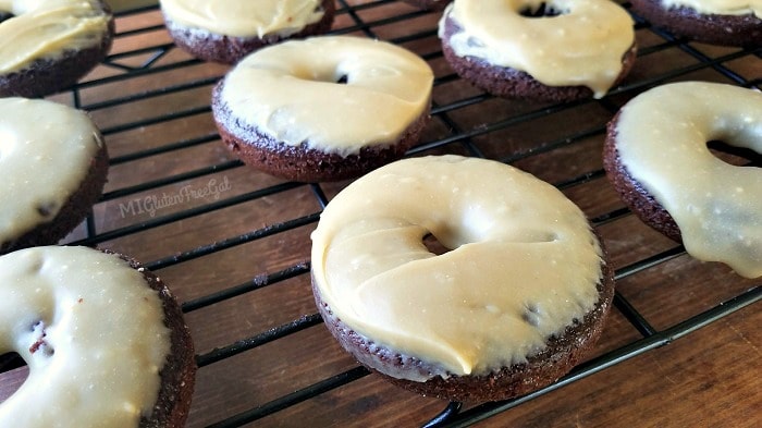 gluten-free chocolate sunbutter donuts glazed with frosting, cooling on a wire rack