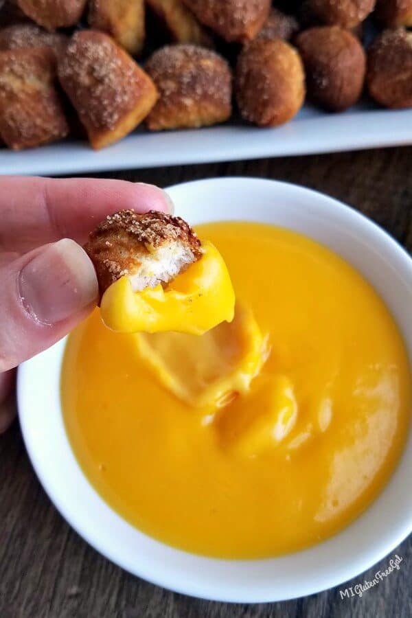 gluten free soft pretzel bites dipped in Full Flavor Foods Cheese sauce