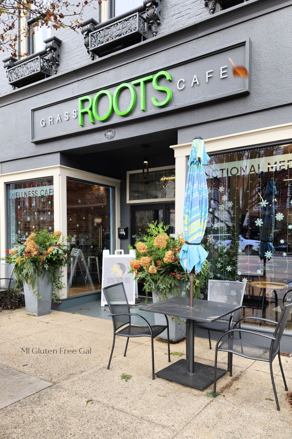 Grassroots Cafe building exterior with patio tables and umbrellas. Outdoor seating is pet friendly. 